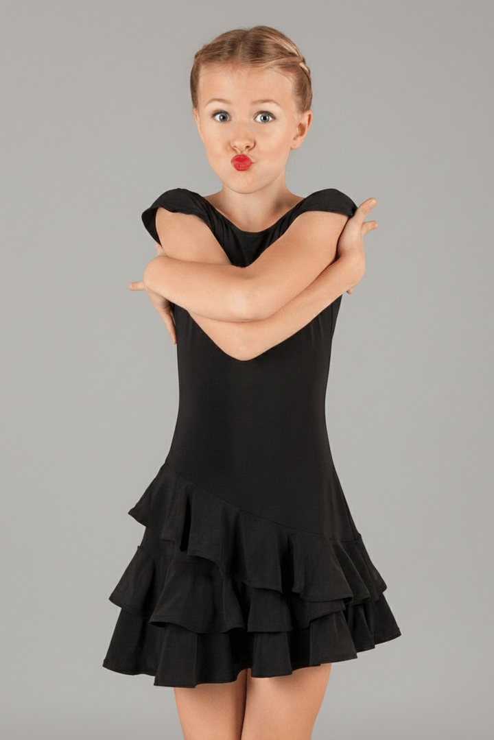 Girl wearing a black dance latin practice dress with a gray background