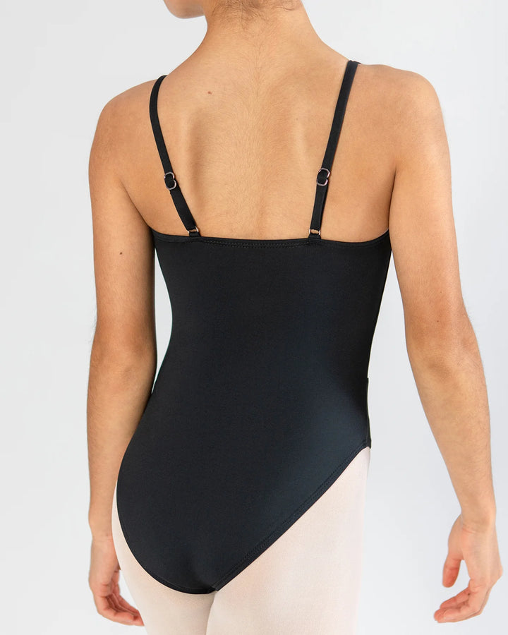 Rear view of a model wearing a black bodysuit with thin adjustable shoulder straps and small metal ring details, paired with light pink tights, against a light gray studio background.